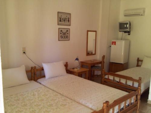 a room with two beds and a refrigerator at Asprovalta Rooms in Kariotes