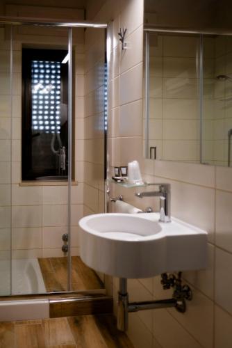 a bathroom with a white sink and a shower at Magic Hotel in Atena Lucana