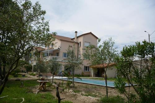 uma villa com uma piscina e uma casa em L'Oiseau Bleu em Tournon-sur-Rhône