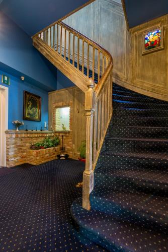 a wooden staircase in a room with blue walls at The Black Swan Hotel in Bruges