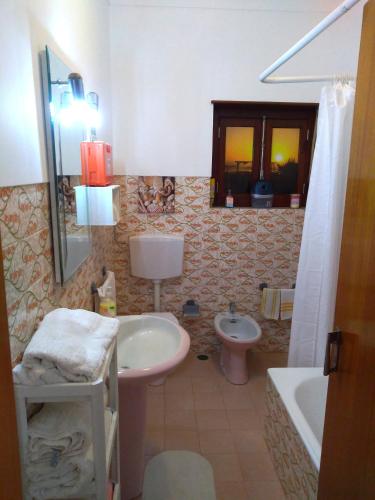 a bathroom with a sink and a toilet and a tub at Beach house with garden in Sintra