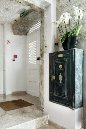 a hallway with a door with a vase of flowers on it at Lisboa Prata Boutique Hotel in Lisbon