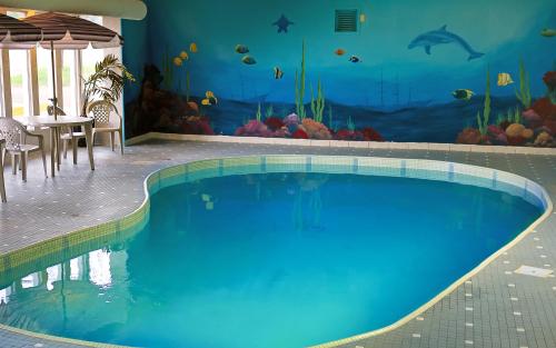 蒙克頓的住宿－蒙克頓/迪耶普海岸酒店，墙上挂着鱼壁画的游泳池