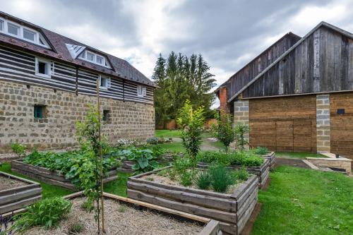 a garden in front of a building with plants at Homutův statek in Kokořín
