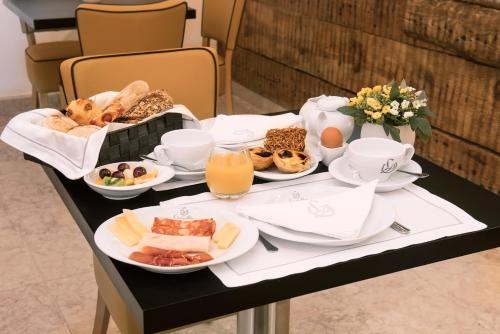 a table with a tray of breakfast foods and orange juice at Lisboa Prata Boutique Hotel in Lisbon