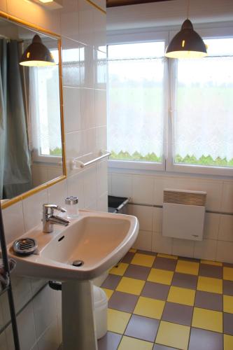 W łazience znajduje się umywalka i lustro. w obiekcie Gites de la Haie w mieście Plouégat-Moysan