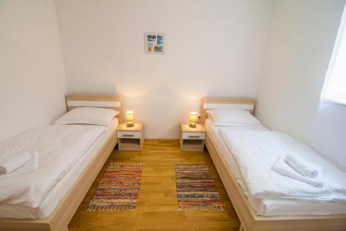 two beds in a room with two lights on them at Villa Nikola - pool side apartments in Bol