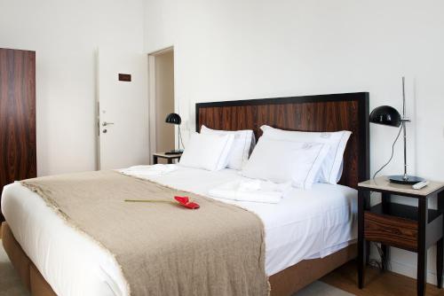 a bedroom with a bed with a red rose on it at Lisboa Prata Boutique Hotel in Lisbon