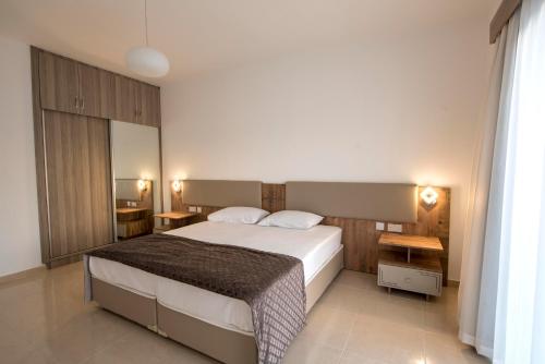 a bedroom with a large bed and two tables at Deniz Airport Suites in North Nicosia