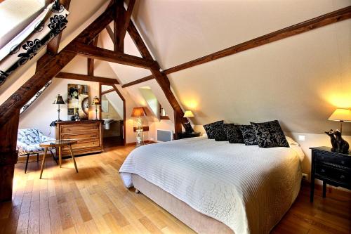 - une chambre mansardée avec un grand lit dans l'établissement Les Fermes de Florence Bien être et nature, à Les Champeaux