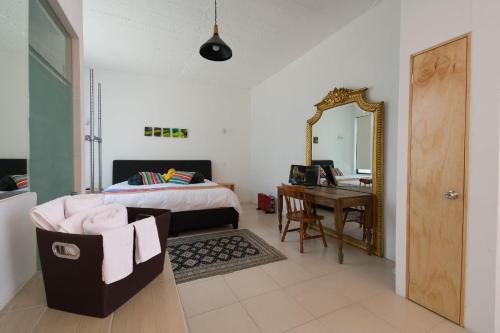 1 dormitorio con cama, escritorio y espejo en FL 59 Coyoacan at your doorstep!, en Ciudad de México