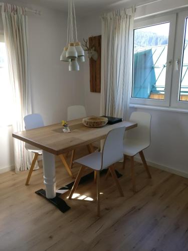 a dining room table with white chairs and a window at Pension Edelweiss Top 25 in Gosau
