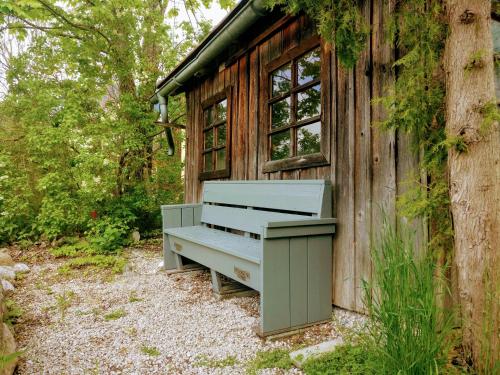 a bench sitting outside of a wooden building at Pension Edelweiss Top 25 in Gosau
