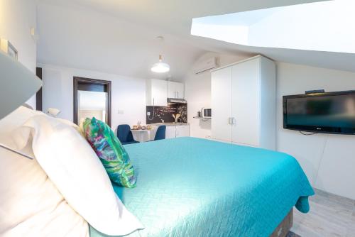 a bedroom with a blue bed and a television at Apartments Grgich in Dubrovnik