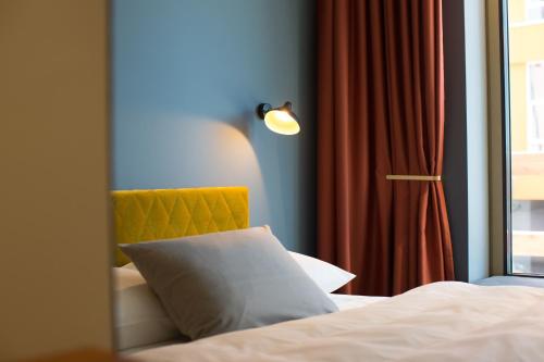 a bedroom with a bed and a lamp at gambino hotel WERKSVIERTEL in Munich