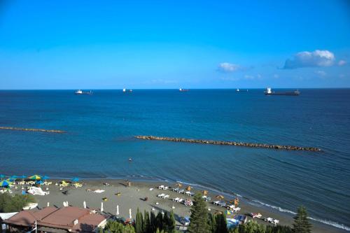 a beach with a group of people on the water at Pier Beach Hotel Apartments in Limassol