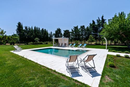 einen Pool mit vier Stühlen und einem Pool in der Unterkunft Olive Garden House in Borgagne