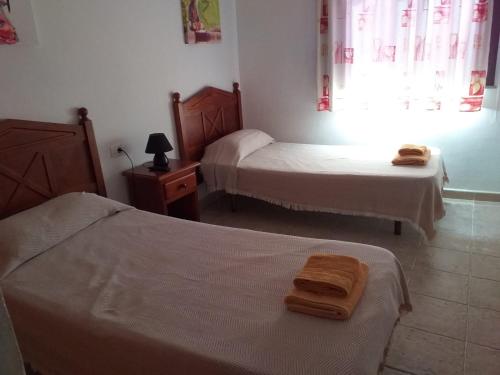 sypialnia z 2 łóżkami i ręcznikami w obiekcie APARTAMENTOS MARIA w mieście La Restinga