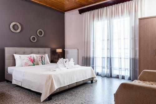 a bedroom with a large bed and a large window at Roxanne’s Home in Limenas