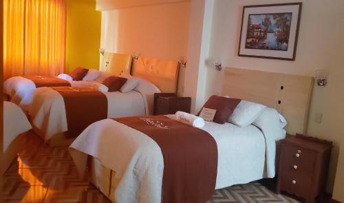 a hotel room with three beds in a room at Morales Guest House in Huaraz