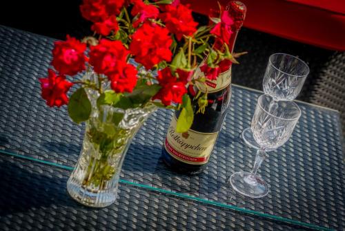 uma garrafa de vinho e um vaso de flores sobre uma mesa em Apartments Ivanka em Ston