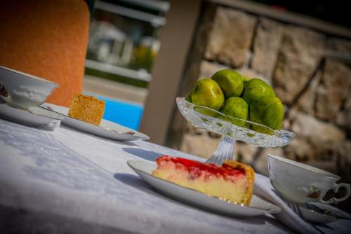 a table with three plates of food and a bowl of limes at Apartments Ivanka in Ston