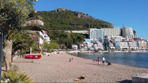 a group of people on a beach near the water at Lunde Sea View Apartment in Rafailovici