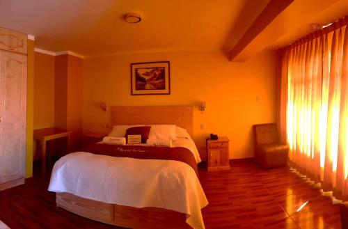 a bedroom with a bed with white sheets and a window at Morales Guest House in Huaraz