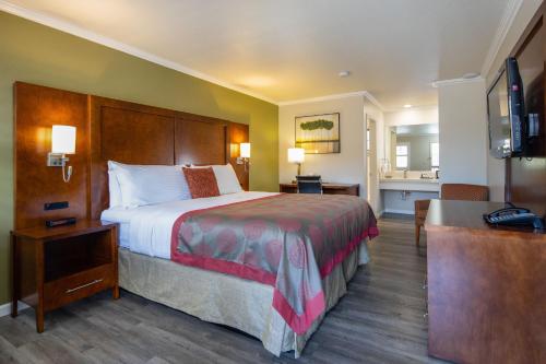 a hotel room with a large bed and a bathroom at Ramada by Wyndham Mountain View in Mountain View