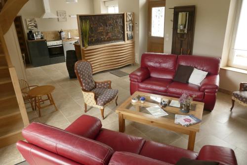 a living room with a red couch and a table at Le Chat Qui Veille in Bayeux