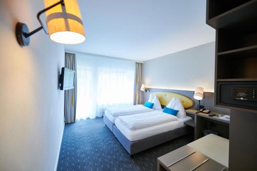 a hotel room with a bed and a television at Hotel Holiday Thun in Thun