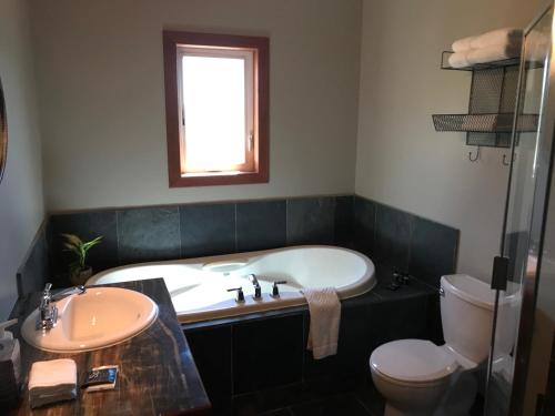 La salle de bains est pourvue d'une baignoire, de toilettes et d'un lavabo. dans l'établissement Wesbert Winery & Guest Suites, à Penticton