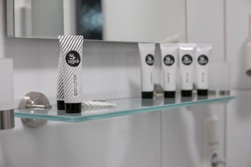 a glass shelf in a bathroom with four toothbrushes at Gästezimmer am alten Kaffee Hof in Suderburg