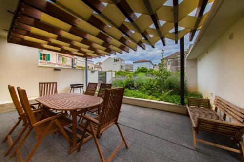 a patio with a wooden table and chairs on a balcony at Bella Vista Suites in Vis