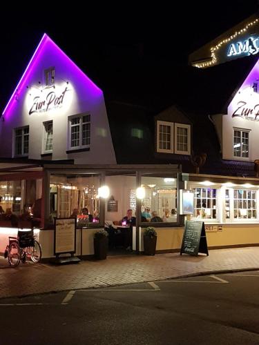 クックスハーフェンにあるHotel Gasthof Zur Postの紫色のライトが灯る夜のファストフード店