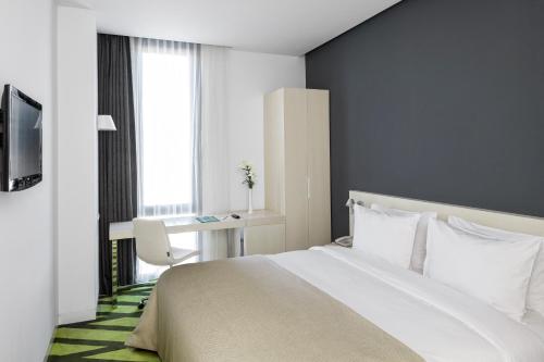 een slaapkamer met een bed, een bureau en een raam bij Workinn Hotel in Gebze