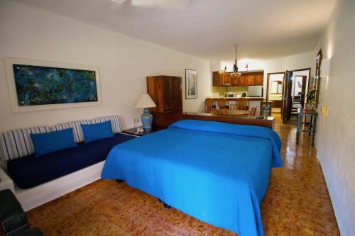 a bedroom with a blue bed and a couch at Villas del Sol en Los Tules in Puerto Vallarta
