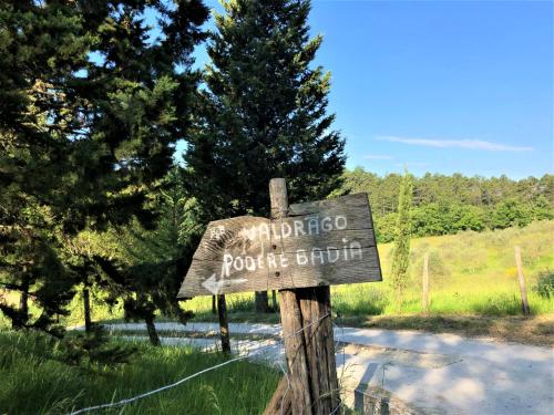 a wooden sign on a fence next to a road at Podere Badia Valdrago Agriturismo Mugello Circuit in Scarperia