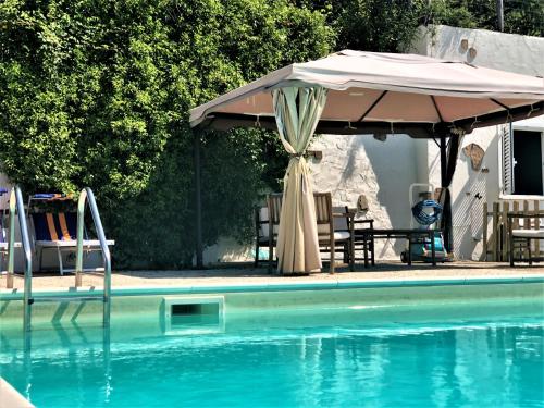 an umbrella and chairs next to a swimming pool at Podere Badia Valdrago Agriturismo Mugello Circuit in Scarperia