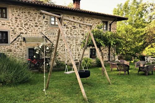 a swing set in the yard of a house at Podere Badia Valdrago Agriturismo Mugello Circuit in Scarperia
