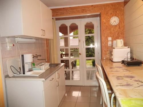 kuchnia z białymi szafkami i blatem w obiekcie Maria Apartman w Hévízie
