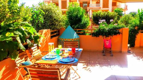 a table and chairs in a backyard with an orange fence at Deluxe garden flat near Terra-Mítica in Benidorm