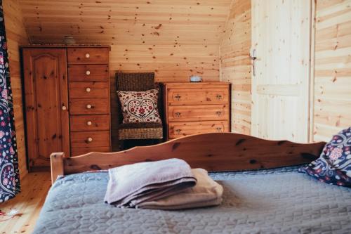 um quarto com uma cama num chalé de madeira em Tumiło em Dziwnów