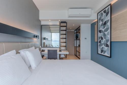 a bedroom with a white bed and a desk at Hotel Avra by Smile hotels - Free Airport Shuttle in Rafina
