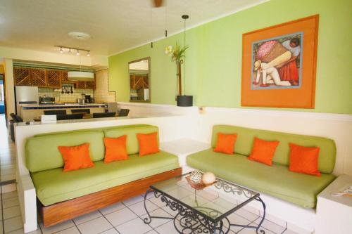 a living room with two green couches and a table at Villas del Sol en Los Tules in Puerto Vallarta