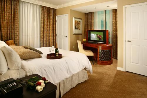 une chambre d'hôtel avec un lit et une télévision dans l'établissement Luxury Suites International at The Signature, à Las Vegas