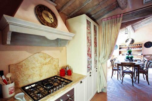a kitchen with a stove and a clock on the wall at Podere La Strega in Siena