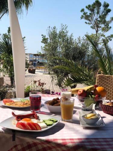 una mesa de picnic con comida y bebida en la playa en Hotel Jon, en Dhërmi