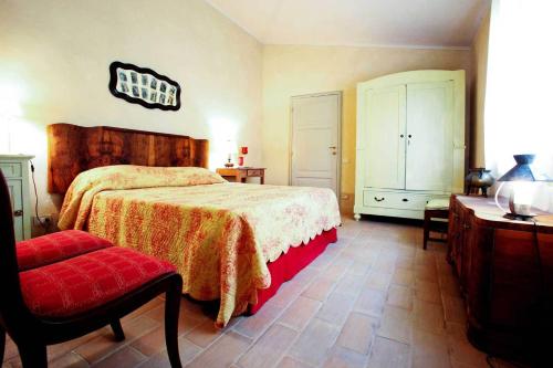 a bedroom with a bed and a chair and a table at Podere La Strega in Siena