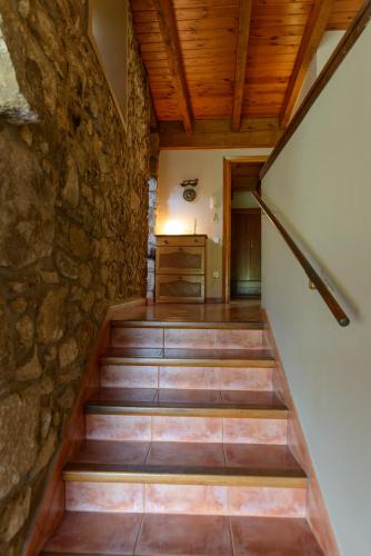 a staircase in a house with a stone wall at Can MiA in Bas